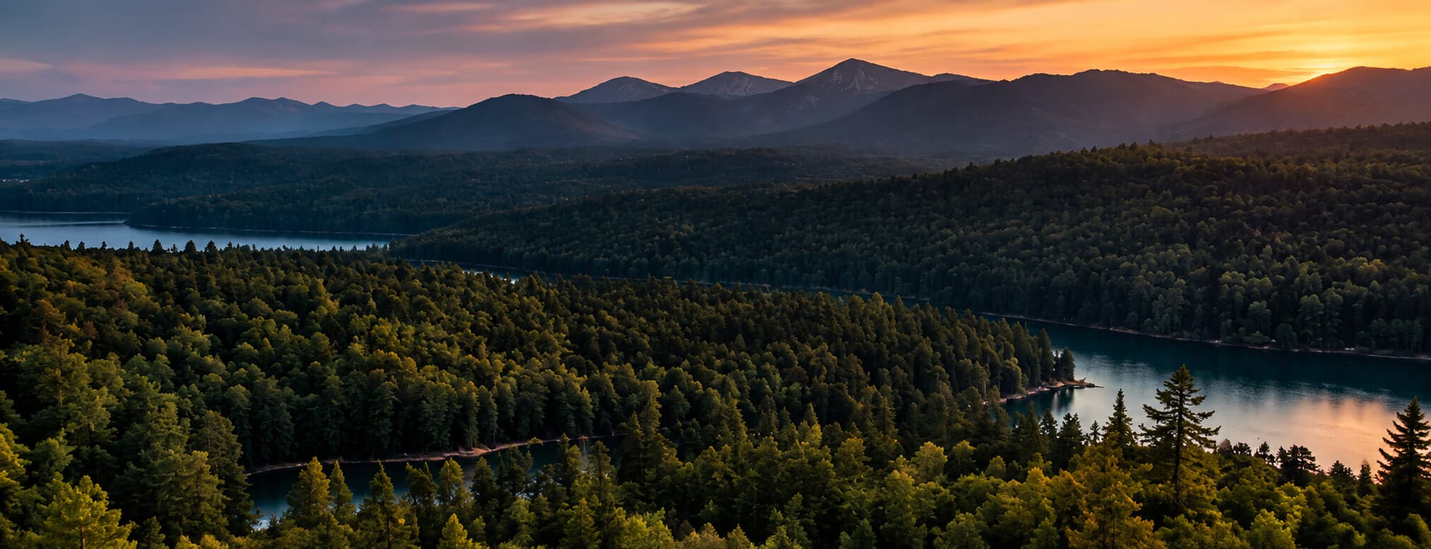 Forest river valley and mountains at sunset